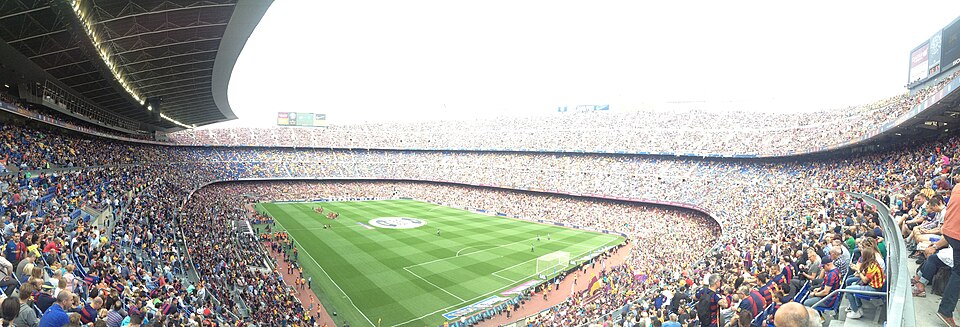 Hinchas viendo un partido en un bar deportivo durante la noche
